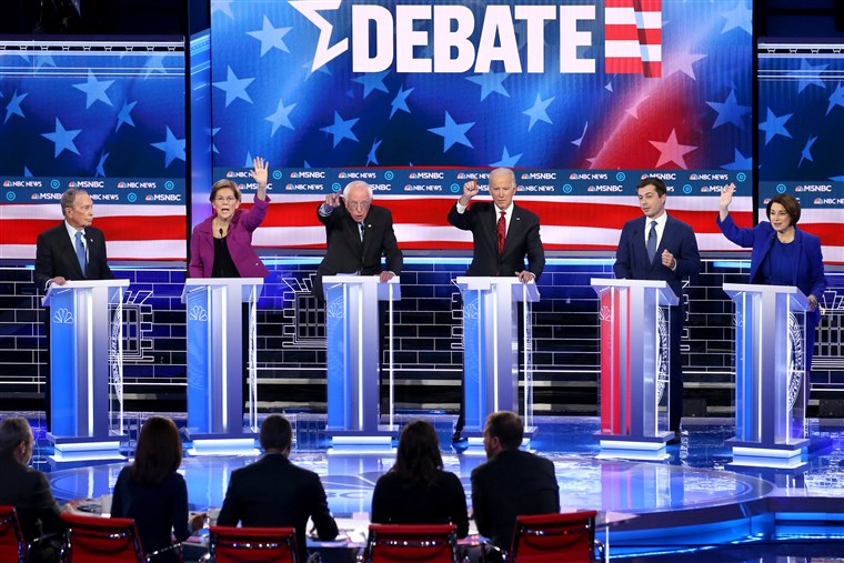 Six Democratic candidates vie for the moderators attention as they participate in the presidential primary debate in Las Vegas