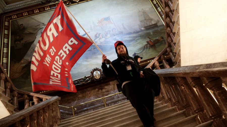 WASHINGTON, DC - JANUARY 06: A protester holds a Trump flag inside the US Capitol Building near the Senate Chamber on January 06, 2021 in Washington, DC. Congress held a joint session that day to ratify President-elect Joe Biden's 306-232 Electoral College win over President Donald Trump. A group of Republican senators said they would reject the Electoral College votes of several states unless Congress appointed a commission to audit the election results. (Photo by Win McNamee/Getty Images)